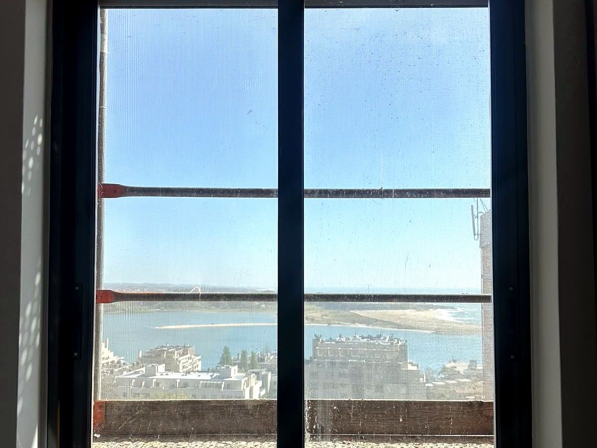 Depois: caixilharia pintada de branco, com vista para a marina
