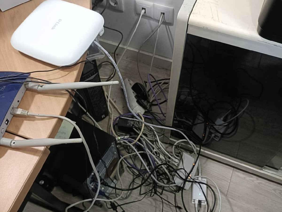 Antes: cabos, routers e fontes de alimentação amontoados debaixo da secretária