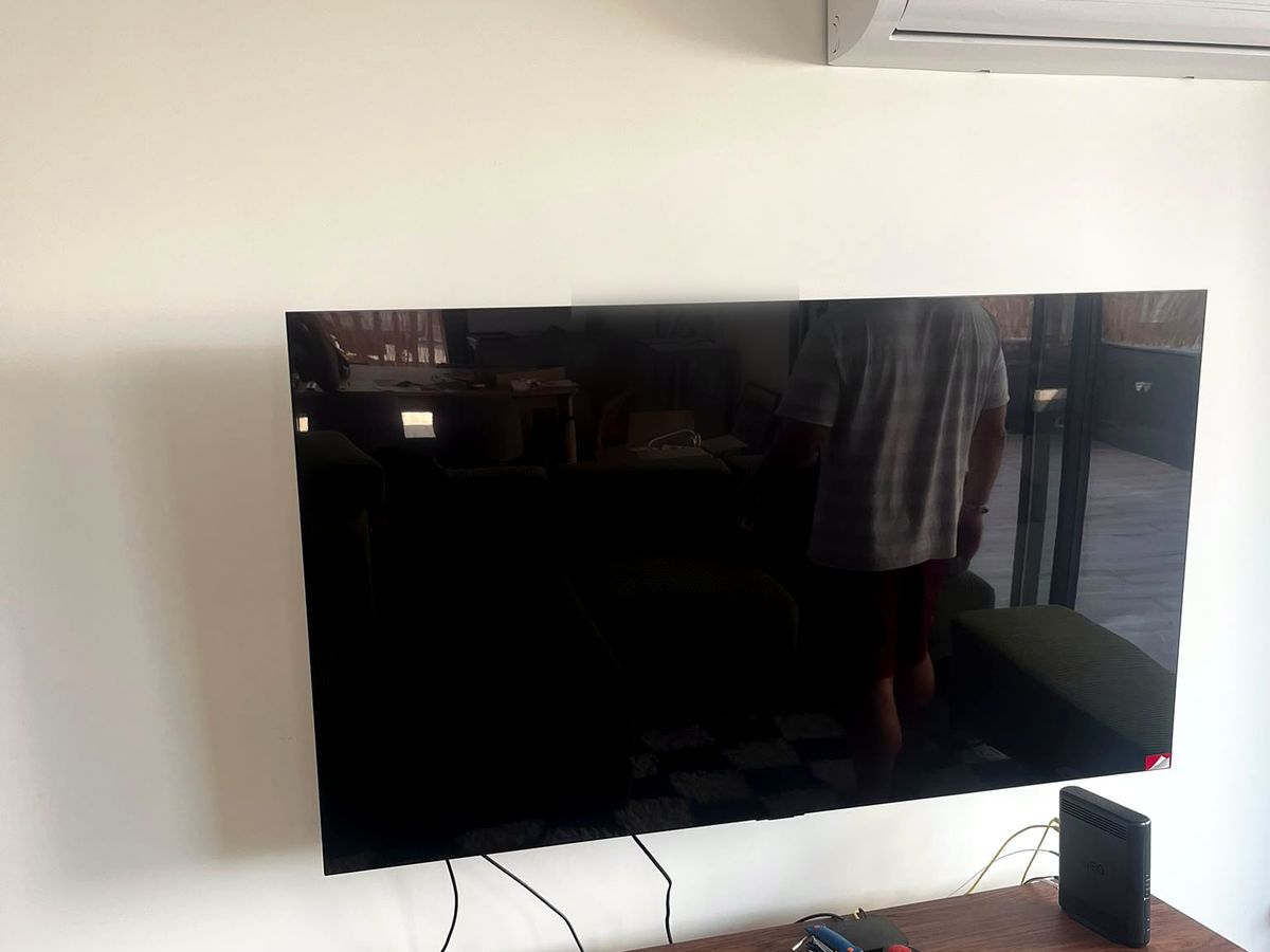 Televisor grande fixo na parede de uma sala