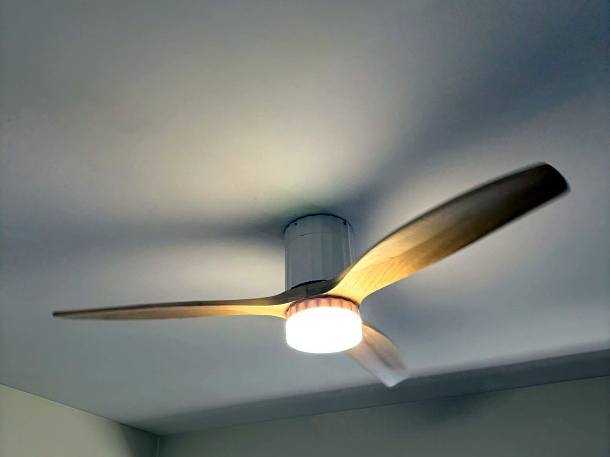 Ventoinha de teto com pás de madeira e luz integrada, em teto inclinado